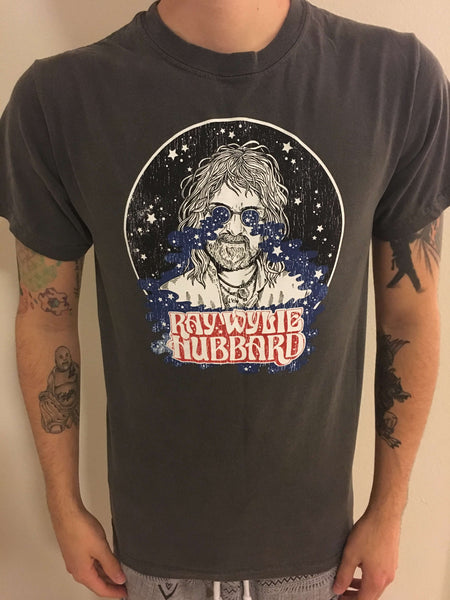 Person wearing a black t-shirt with a graphic design of a person with text 'Rayvyn the Hubbard'.