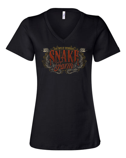 A woman wearing a black short-sleeve V-neck T-shirt with 'Snake Farm' and 'Ray Wylie Hubbard' text on it, paired with blue jeans.